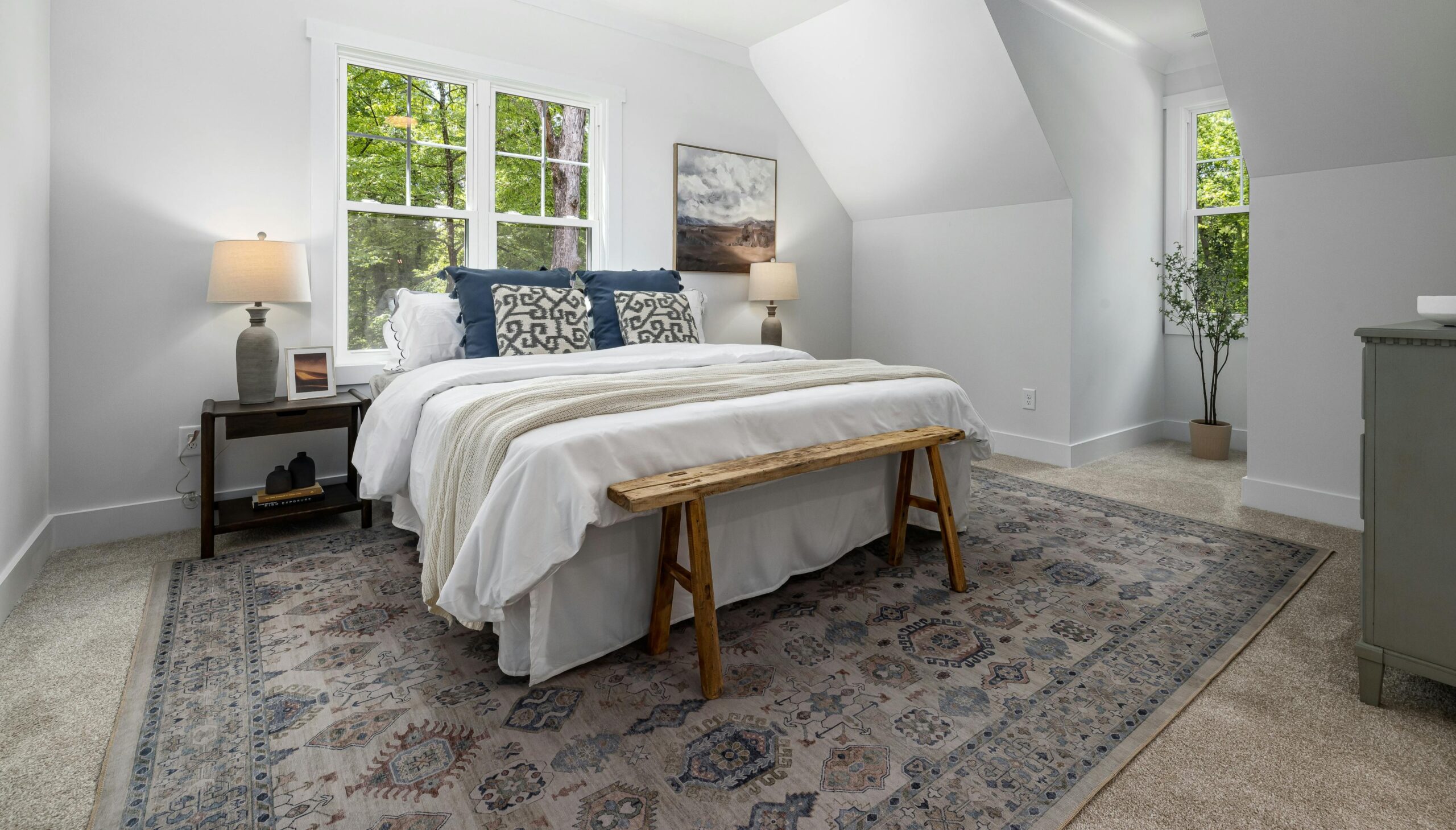 Primary bedroom layered area rug on carpet.